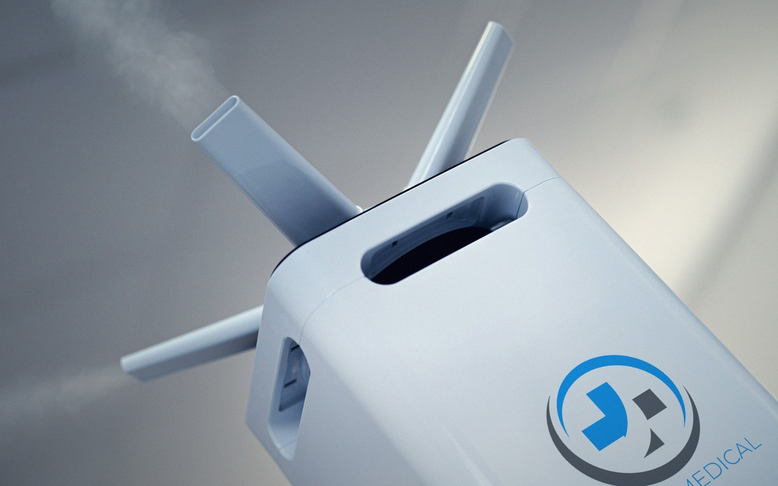 Close-up of a medical device with multiple tubes emitting visible vapor near its handle