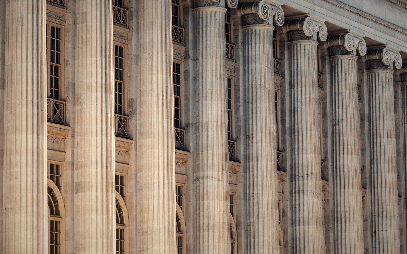 Row of fluted ionic columns lining a classical stone government building facade
